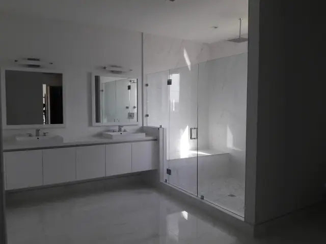 Remodeled bathroom with double vanity and glass shower in Hollywood, FL