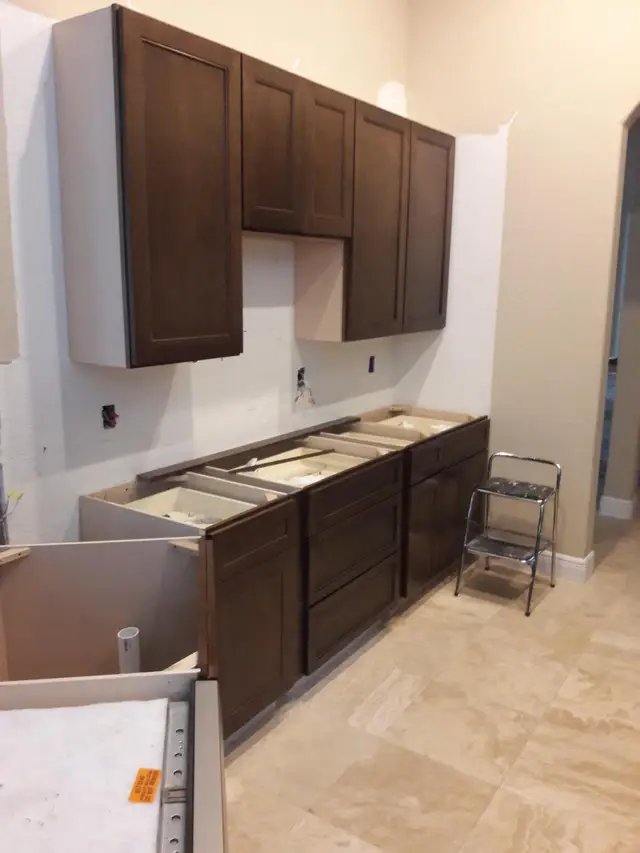 Espresso kitchen cabinet installation in progress